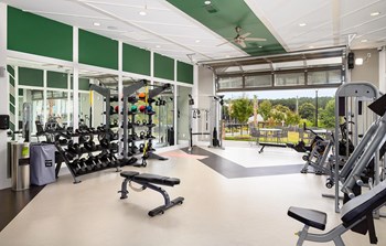 Fitness Center with the garage door open leading to patio seating outside